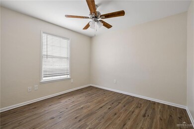Spare room featuring wood finished floors, baseboards, and ceiling fan