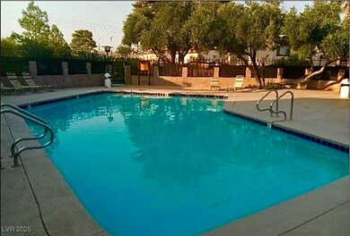 Community pool with a patio area and fence