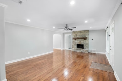 Unfurnished living room featuring ceiling fan, wo