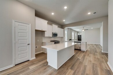 Kitchen featuring a peninsula, white cabinets, a center island, backsplash, and recessed lighting