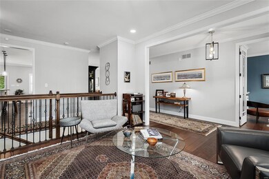 Just one of the custom modifications to this Lombardo Summit floor plan is dual sided rails and spindles in lieu of walls creating an open space at the Dining Room and hallway.