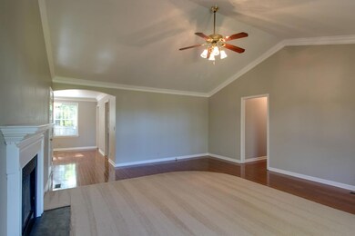 Living room opens through arched doorway into dining room.