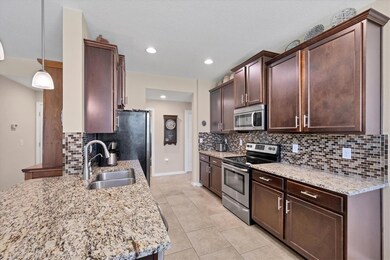 Well equipped kitchen with tile backsplash and stone coynters