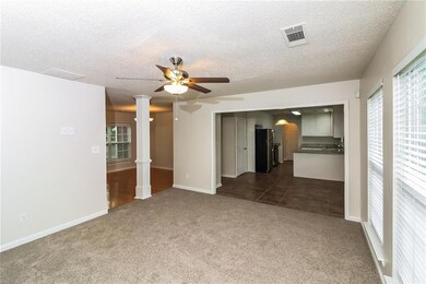 Carpeted spare room with decorative columns, a tex