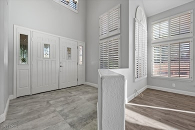 Entrance foyer with baseboards and a high ceiling