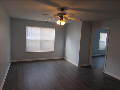 Empty room featuring baseboards, a ceiling fan, an