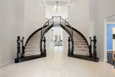 A grand dual staircase welcomes you into this stunning entryway, setting the tone for the elegance and sophistication found throughout the home. Soaring ceilings, abundant natural light, and timeless architectural details make this foyer truly unforgettable.