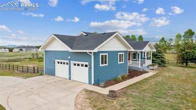View of side of property with a shingled roof, driveway, covered porch, and a garage