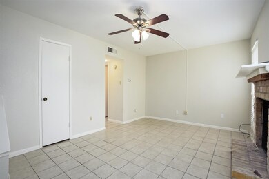 Spacious living room with ceiling fan and fireplac