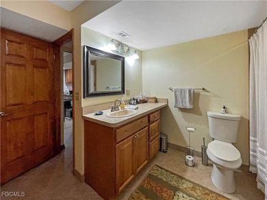 Bathroom with light tile patterned floors, vanity, and a shower with curtain