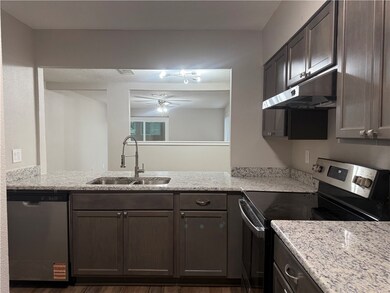 Kitchen featuring a sink, light stone counters, un
