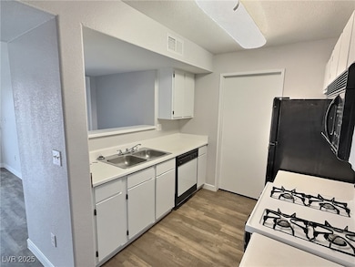 Kitchen with a sink, wood finished floors, dishwas