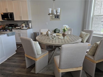 Dining space featuring dark wood-style flooring and a chandelier