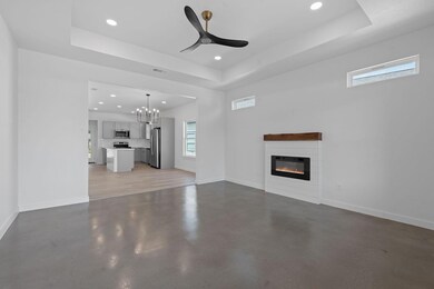 Unfurnished living room featuring a raised ceilin