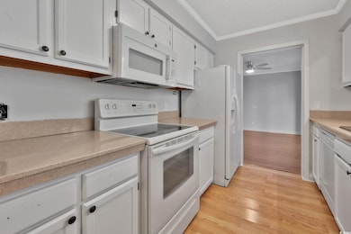 Kitchen featuring white cabinetry, ceiling fan, li