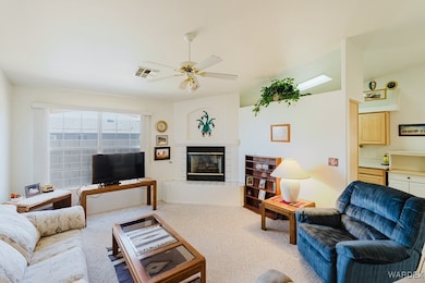 Living room with carpet flooring, ceiling fan, and