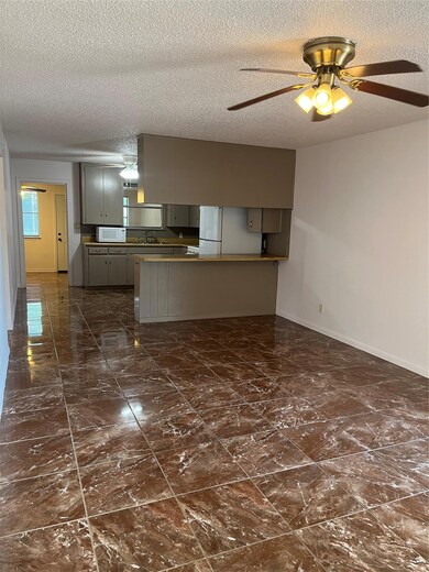 Kitchen featuring a sink, baseboards, gray cabine