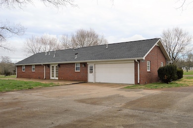 Back of home features a large turn around concrete area