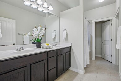 Bathroom with tile patterned floors, double vanit