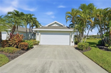 View of front of property with driveway, roof with shingles, stucco siding, and a front yard
