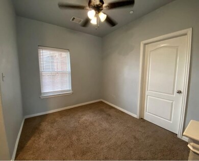Carpeted spare room featuring baseboards and ceiling fan