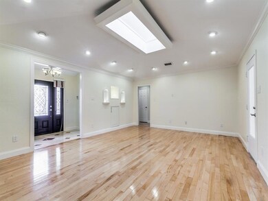 The large living room with a skylight  and  hardwo
