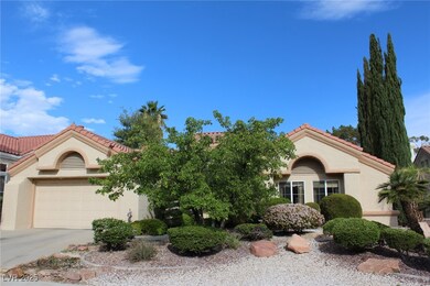 View of front of property featuring a garage, a ti