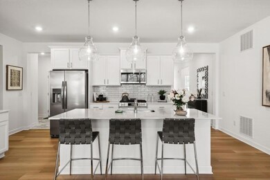 (Photo of a decorated model, actual homes finishes will vary) The spacious kitchen feature a large center island, quartz countertops, LVP floors, stainless appliances and more!
