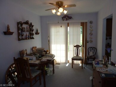 Dining room with lighted paddle ceiling fan, carpe