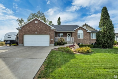 Ranch-style home with brick siding, covered porch, driveway, and a front lawn