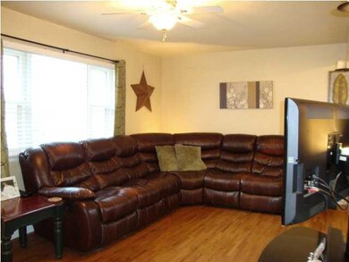 Spacious living room with custom wood blinds. New 
