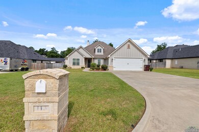 View of front of house with board and batten siding, concrete driveway, a chimney, and an attached garage