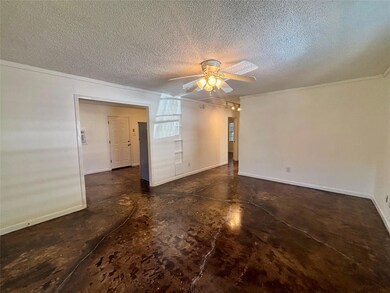 Empty room with concrete flooring, a textured ceiling, ceiling fan, and crown molding