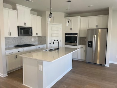 Kitchen featuring dark wood-style floors, applianc