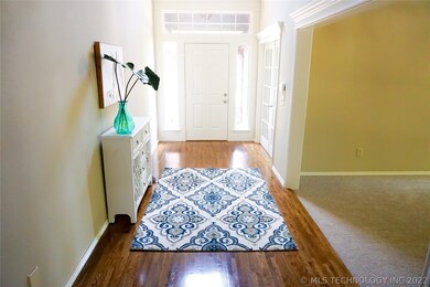 Tall ceiling entry flanked by office and dining ro