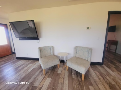 Sitting room with wood finished floors and basebo