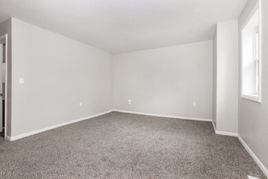Spare room with carpet and baseboards