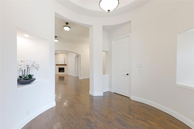 Corridor with dark wood-style floors, arched walkw