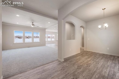 Empty room with ceiling fan, wood finished floors, a chandelier, recessed lighting, and arched walkways