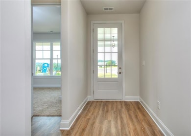 Doorway to outside featuring wood-style finished floors and baseboards