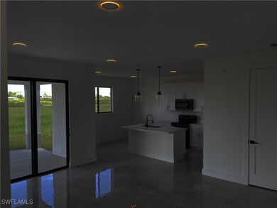 Kitchen with black appliances, sink, an island wit