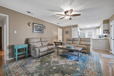 Living area with light wood finished floors and ceiling fan
