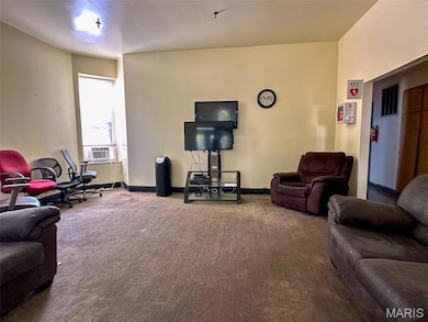Carpeted living area featuring baseboards