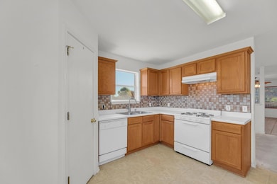 Kitchen featuring white appliances, tasteful back