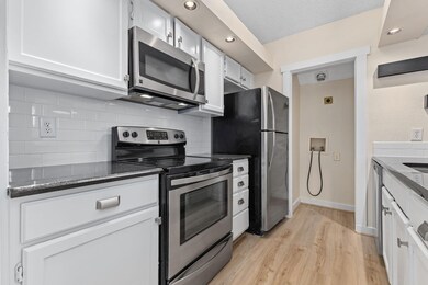 Kitchen with light wood-type flooring, backsplash,