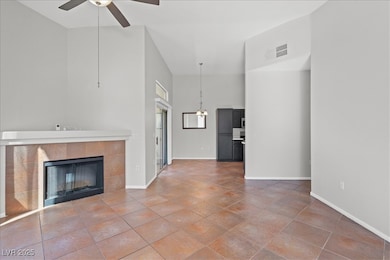 Unfurnished living room featuring ceiling fan, a t