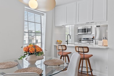 Kitchen featuring white cabinets, a sink, light c