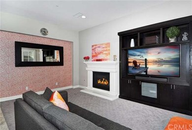 Another wonderful look at the family room of the home which includes upgraded custom wall paper, high-end Burber carpeting and a buiit-in entertainment unit. The room overlooks the oversized kitchen and the serene backyard.