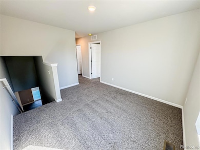 Unfurnished living room featuring carpet flooring and baseboards