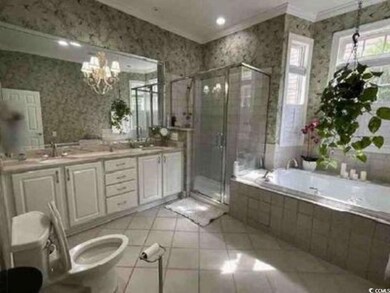 Bathroom with wallpapered walls, crown molding, a garden tub, a shower stall, and double vanity